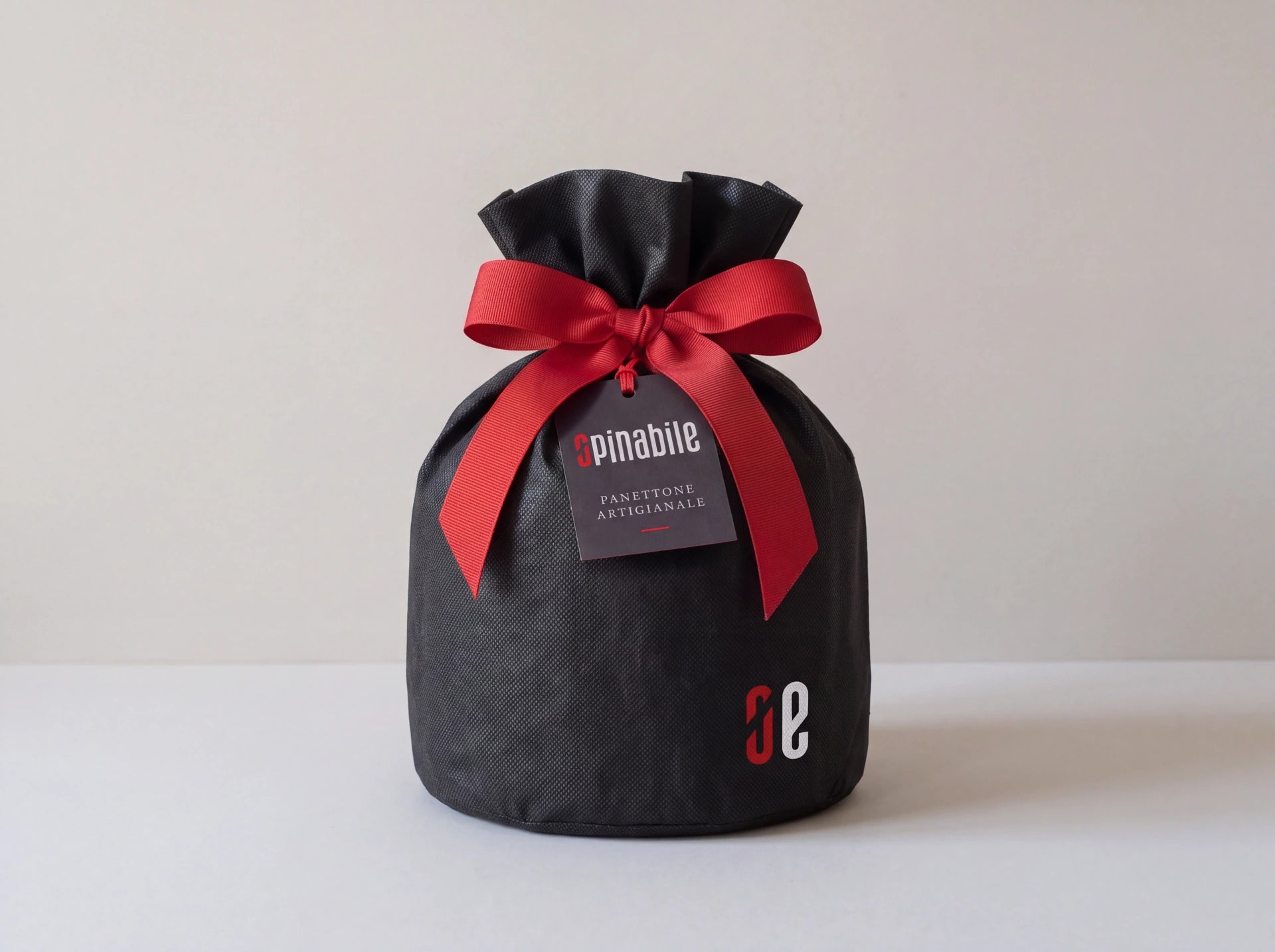 Sacchetto nero Opinabile con fiocco rosso e cartellino